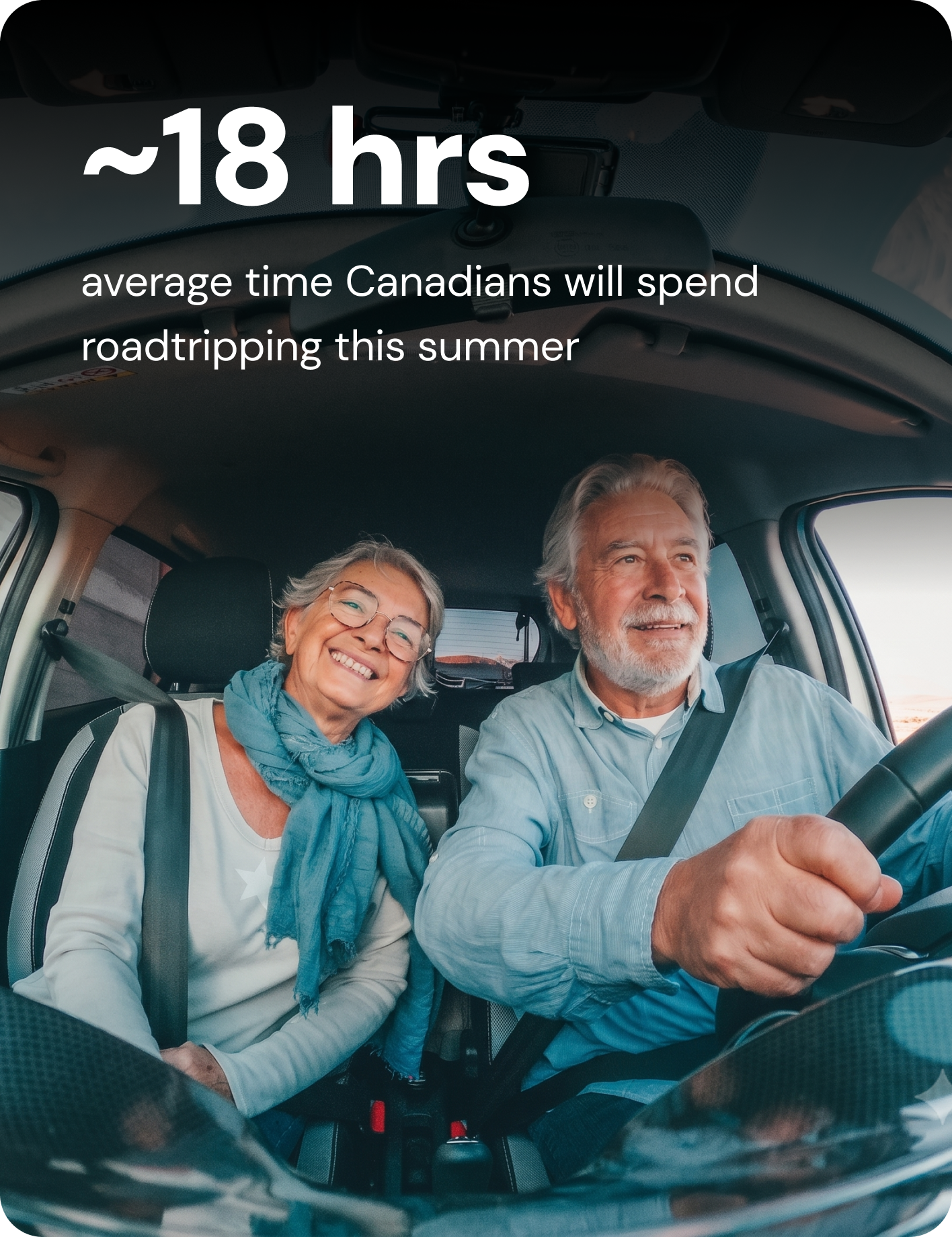 An older man and woman smile in the front seats of their car.