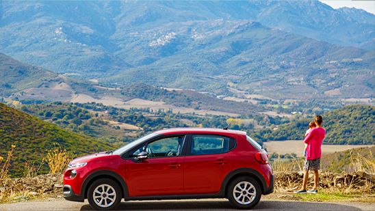 Homme et enfant sortent de leur voiture de location louée sur Turo pour regarder un paysage en France durant l'été