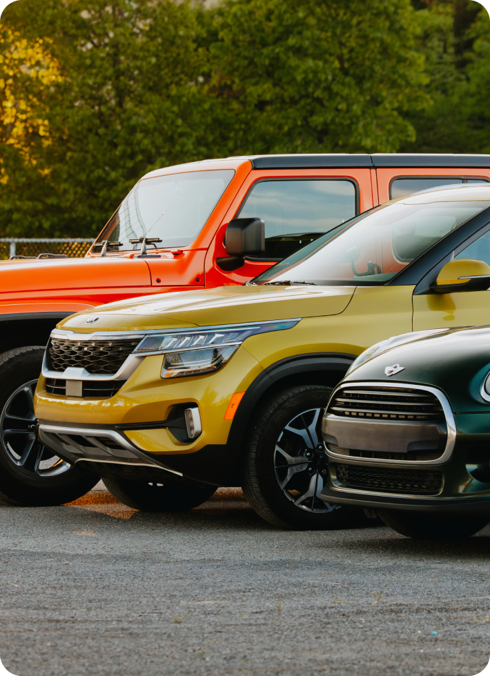 Three cars of different makes and colours parked beside each other.