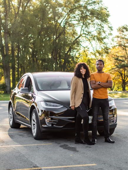 Turo car sharing entrepreneur standing in front of Audi with daughter