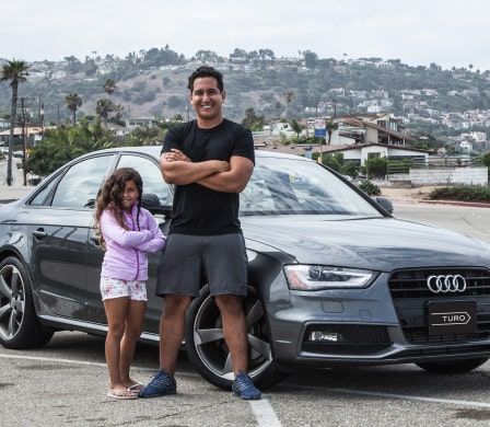 Turo car sharing entrepreneur standing in front of Audi with daughter