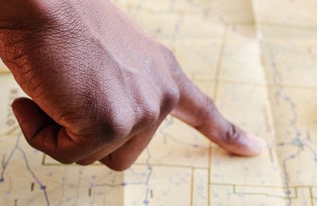 Finger pointing to a location on a printed map