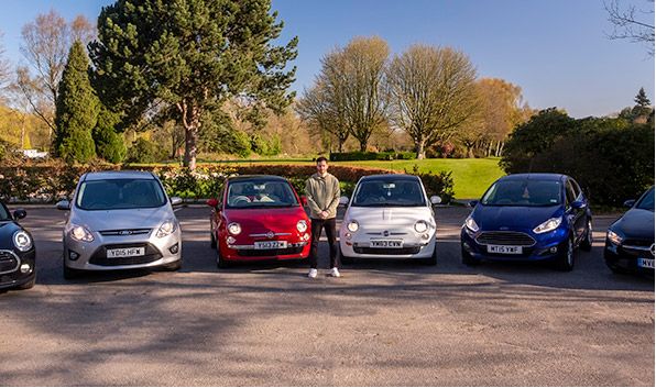 Turo car sharing entrepreneur standing with his fleet of cars