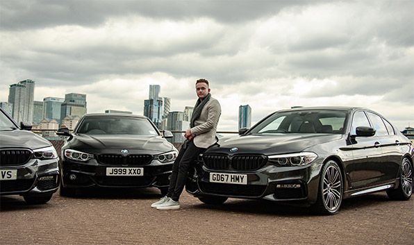 Turo car sharing entrepreneur standing in front of his fleet of BMW's