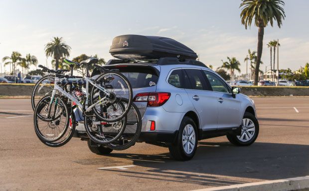 Vehicle with bikes attached to rear rack and storage container mounted on roof