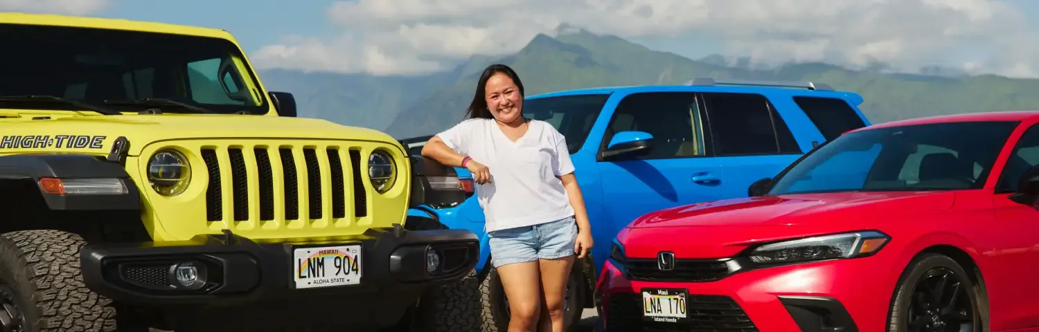 Turo host and small business entrepreneur Lucky D. smiling in front of cars
