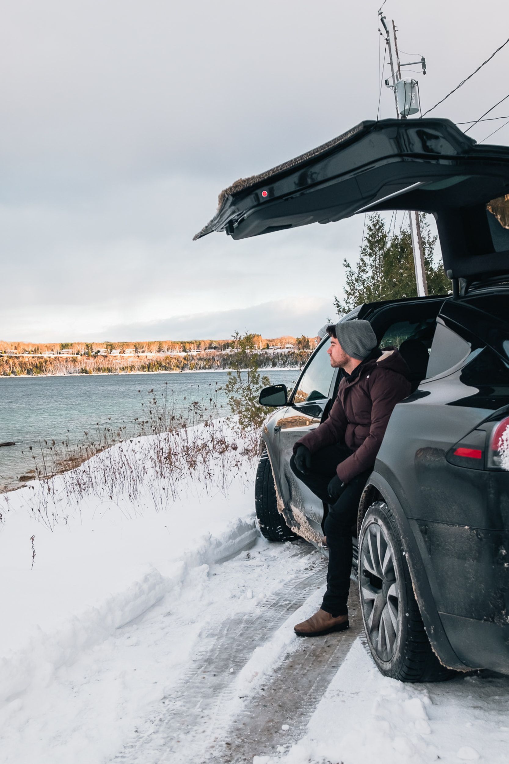 Man standing by black car looking at the view