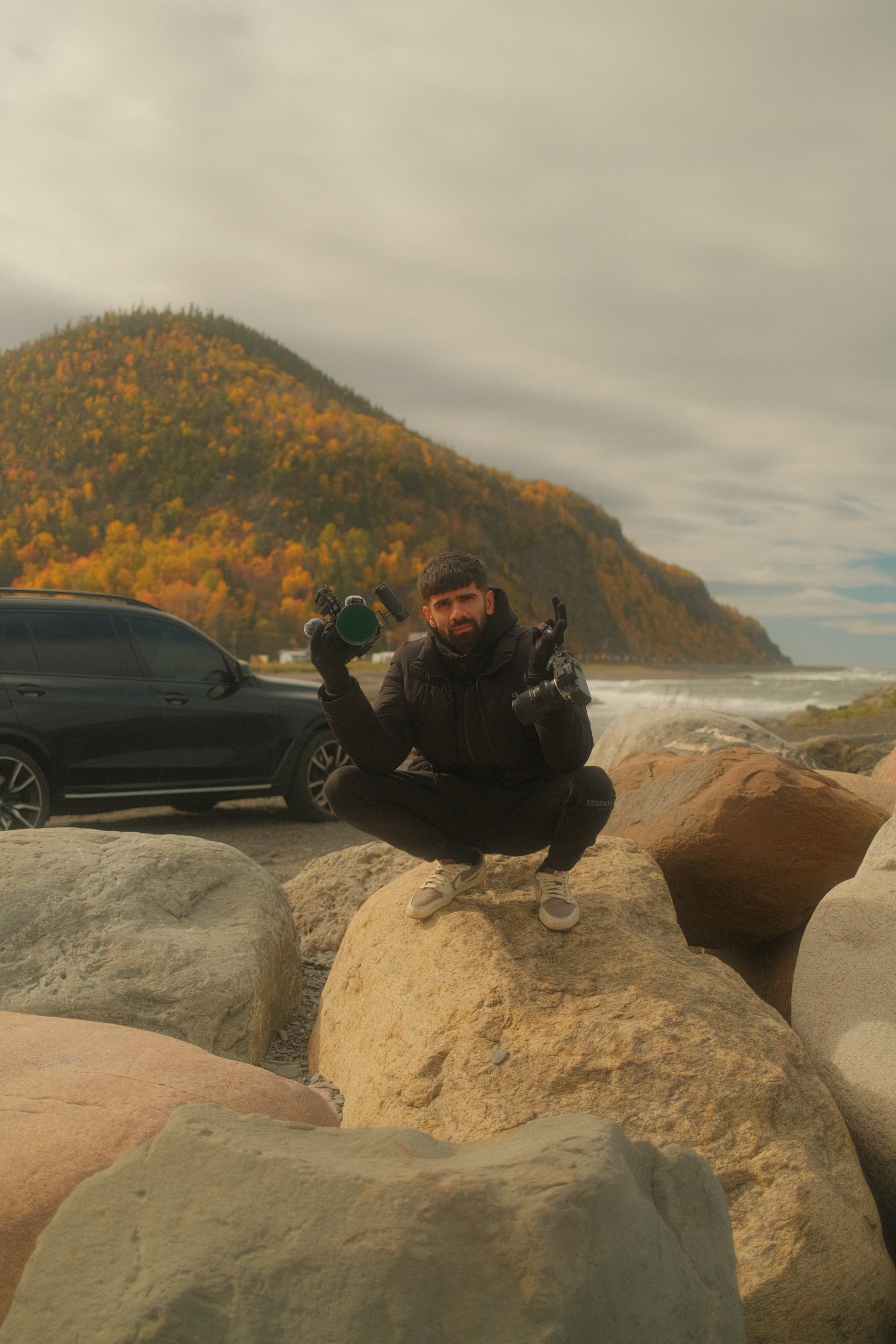 Man standing by black car looking at the view