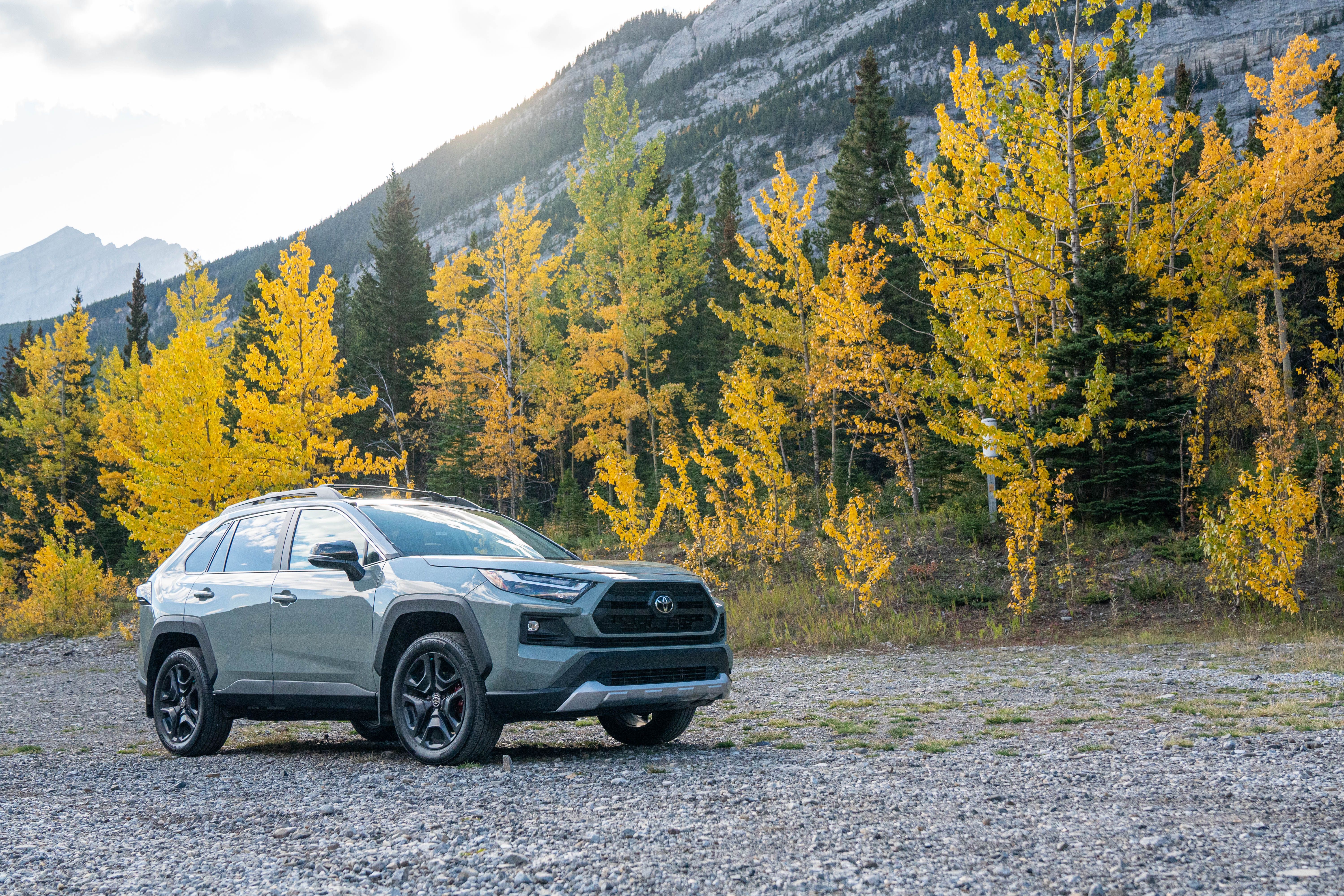 Gray SUV on a gravel road amid yellow aspens and Cascade mountains near Seattle