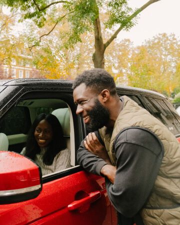 Two people and a red Range Rover