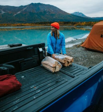 Woman unloading wood out of a truck bed