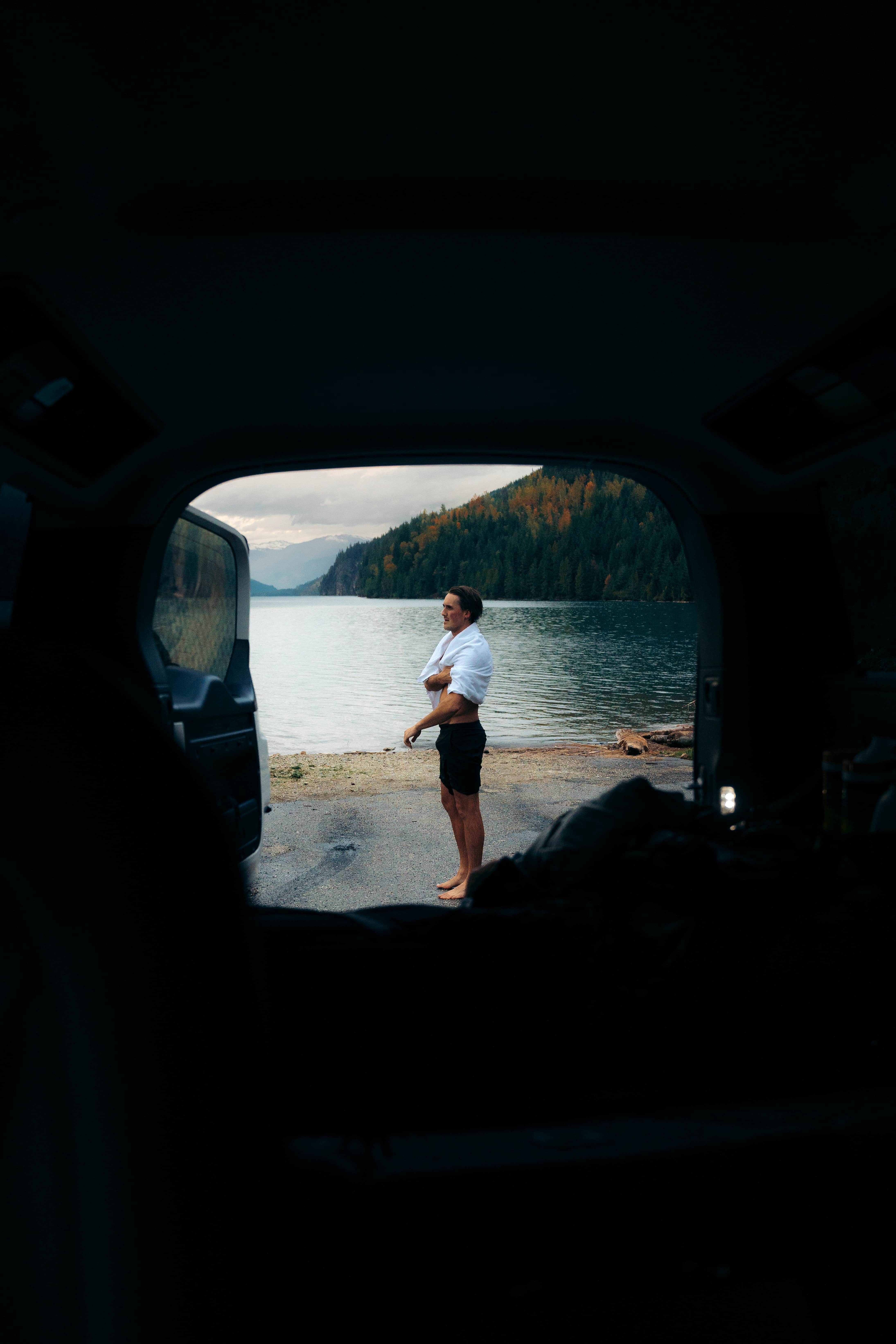 Man standing by black car looking at the view