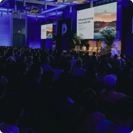 A crowd of people watch Turo’s presentation at the Power Host Summit in Orlando