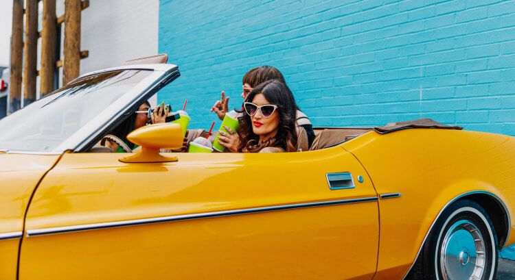 Women in a vintage yellow convertible