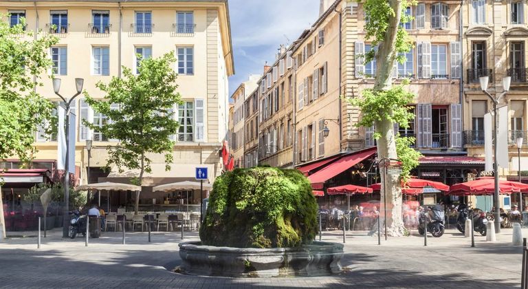 Place d’Aix-en-Provence avec fontaine et cafés en terrasse et option de location de voiture sur Turo