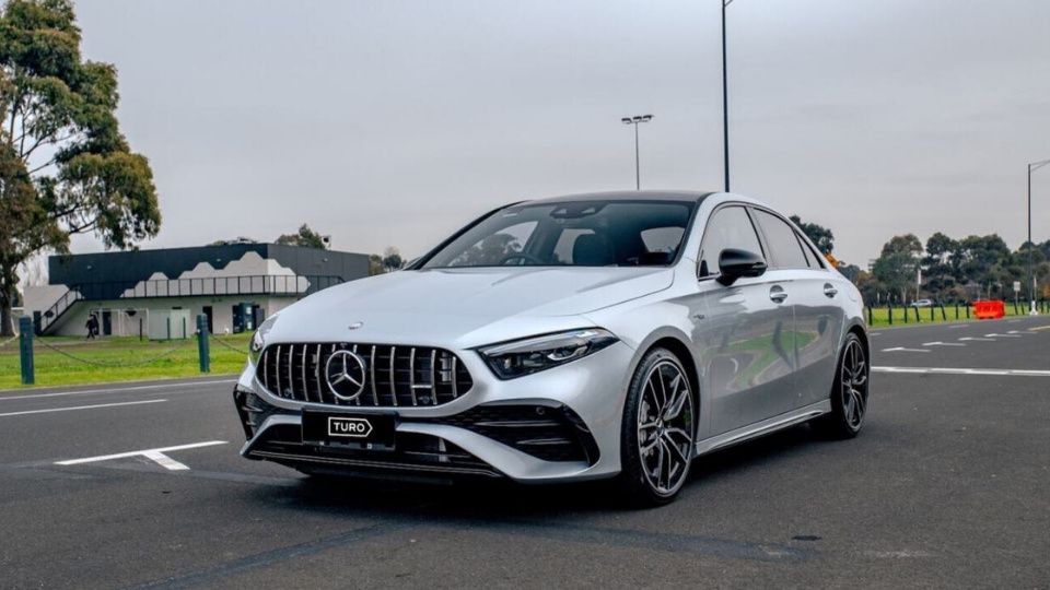 A Turo guest stands next to a Polestar rental car in Melbourne, with the beach in the background