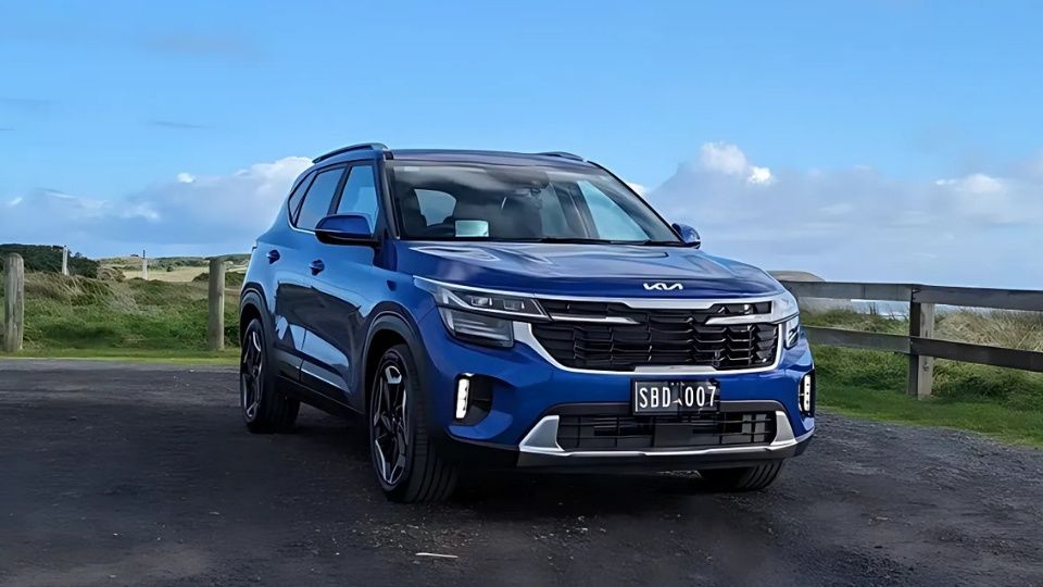 A Turo guest stands next to a Polestar rental car in Melbourne, with the beach in the background