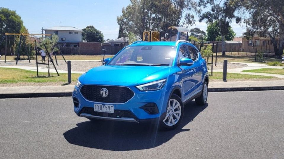 A Turo guest stands next to a Polestar rental car in Melbourne, with the beach in the background
