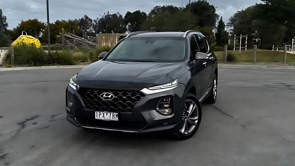 A Turo guest stands next to a Polestar rental car in Melbourne, with the beach in the background