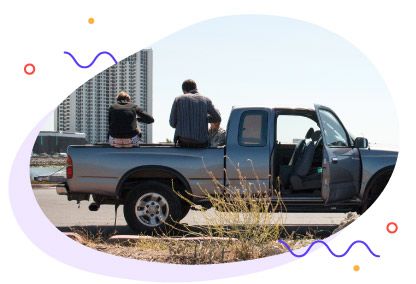Friends sitting in the back of a truck rented on Turo